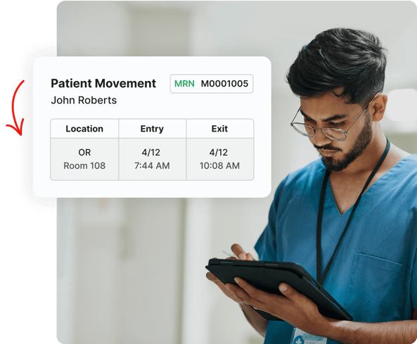 A healthcare worker reviews patient movement details on a tablet in a hospital hallway.