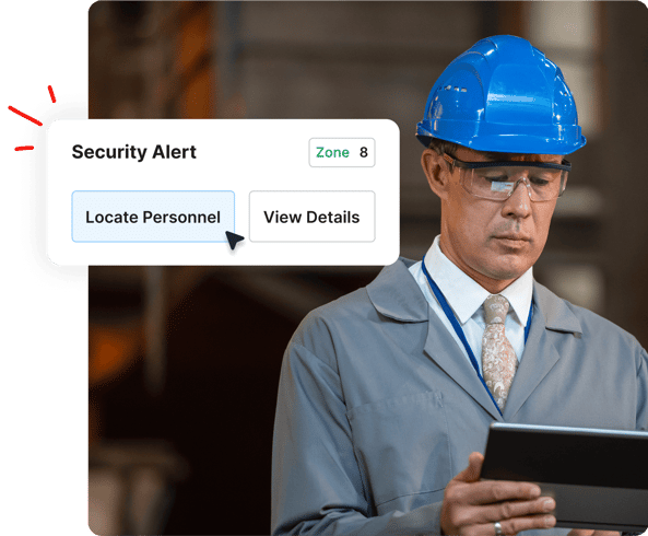Man in a blue hard hat using a tablet, with a security alert popup showing Locate Personnel and View Details.